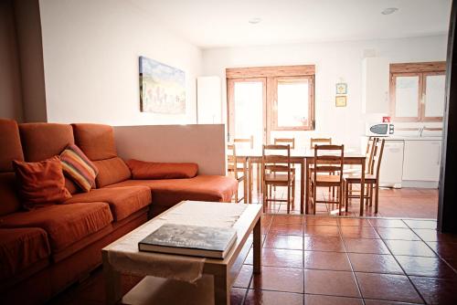 een woonkamer met een bank en een tafel bij Casa La Alegría de La Alcarria I in Torremocha del Campo