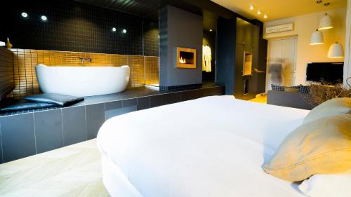 La salle de bains est pourvue d'une baignoire et d'un grand lit. dans l'établissement MiHotel Bellecour, à Lyon