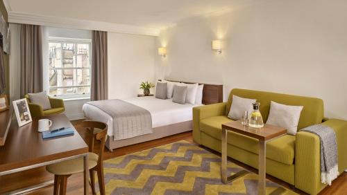 une chambre d'hôtel avec un lit, un canapé et une table dans l'établissement Citadines South Kensington London, à Londres