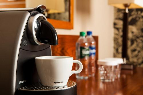 a coffee cup sitting on top of a coffee maker at Mercure Perth Hotel in Perth