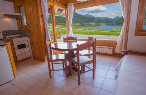 une cuisine avec une table et des chaises ainsi qu'une grande fenêtre dans l'établissement Cabañas Del Lacar, à San Martín de los Andes