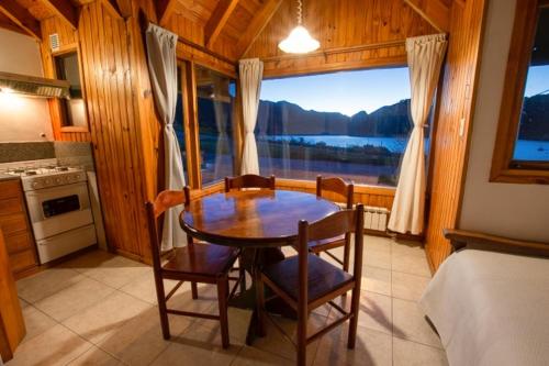 a dining room with a table and chairs and a window at Cabañas Del Lacar in San Martín de los Andes