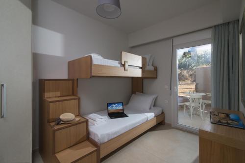 Un dormitorio con una litera y una computadora portátil encima. en Gras Houses - Near to sandy beach, en Agia Pelagia