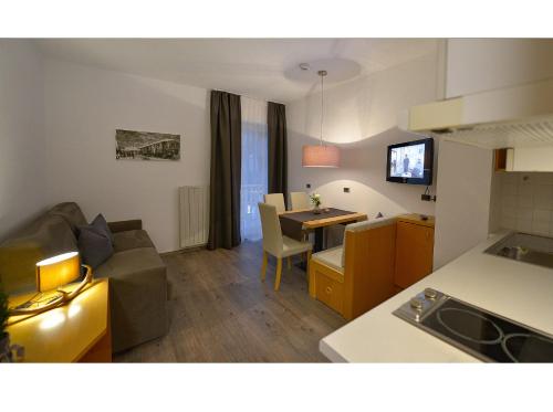 a kitchen and living room with a couch and a table at Apparthotel Central in Campo Tures