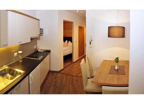 a kitchen and dining room with a table and a bedroom at Apparthotel Central in Campo Tures