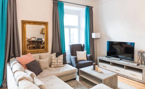 a living room with a couch and a tv at Apartments Hoferhaus - Your Austrian Home in Bad Aussee