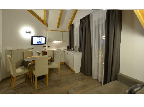a kitchen and dining room with a table and chairs at Apparthotel Central in Campo Tures