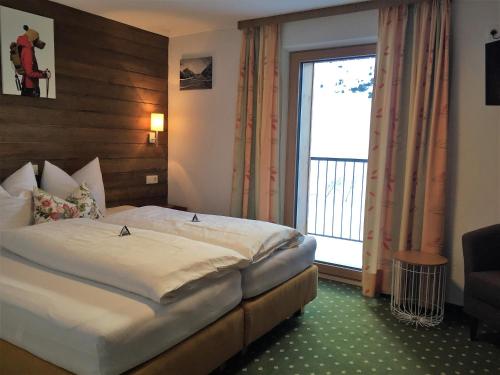 a hotel room with a bed and a large window at Nonas B&B in Galtür