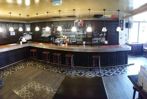 um bar num restaurante com bancos em Hôtel Le Sully La Roche Sur Yon em La Roche-sur-Yon