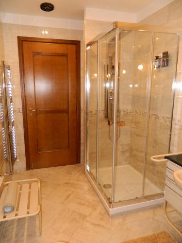 PellezzanoにあるB&B SAN PIOの木製のドア付きのバスルーム(ガラス張りのシャワー付)