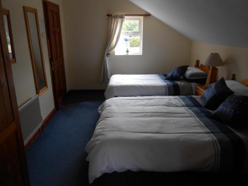 a hotel room with two beds and a window at Birchdale House B&B in Rathdrum