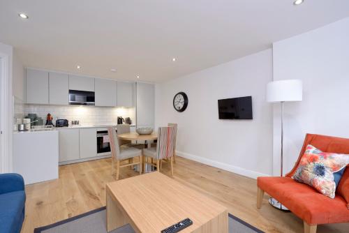 a living room and kitchen with a table and a chair at Destiny Scotland New Town Apartments in Edinburgh