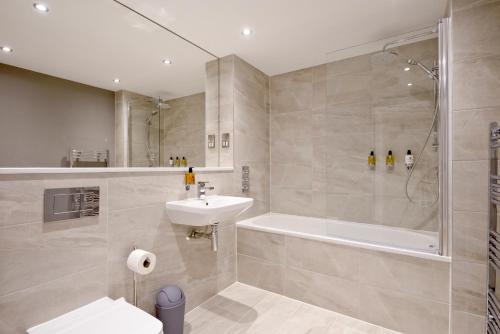 a bathroom with a sink and a tub and a shower at Destiny Scotland New Town Apartments in Edinburgh
