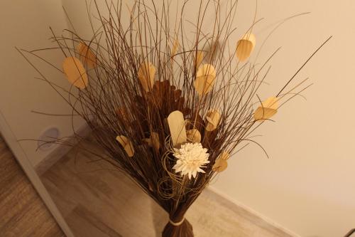 a vase filled with dried grass and a white flower at Apartments Praha Jinonice in Prague