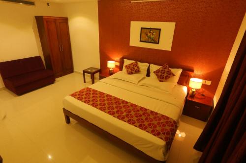 a hotel room with a bed and a chair at Hotel Hilite Inn in Cochin