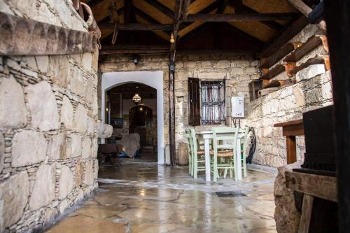 a hallway in a stone building with a table and chairs at Kazani House Lofou in Lofou