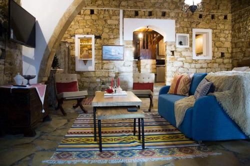 a living room with a blue couch and a table at Kazani House Lofou in Lofou