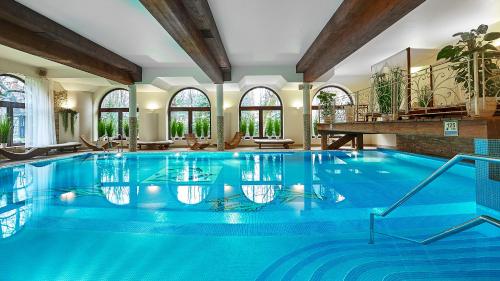 a large swimming pool in a house with a large swimming pool at Grand Hotel Stamary in Zakopane