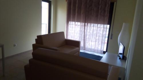 a living room with a couch and a window at Alto dos Navegantes in Armação de Pêra
