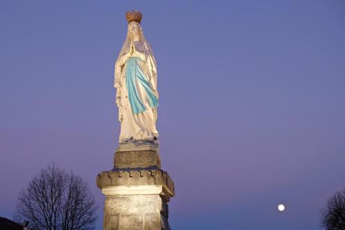 a statue of the statue of liberty with the moon in the background at la Résidence Berceau de Bernadette - Bernadette's cradle - Near Bernadette'House in Lourdes