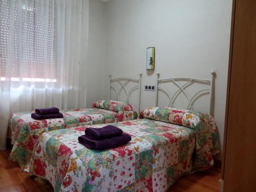 zwei Betten in einem Schlafzimmer mit zwei Handtüchern darauf in der Unterkunft Cálfred Iglesia Santa Teresita in Logroño