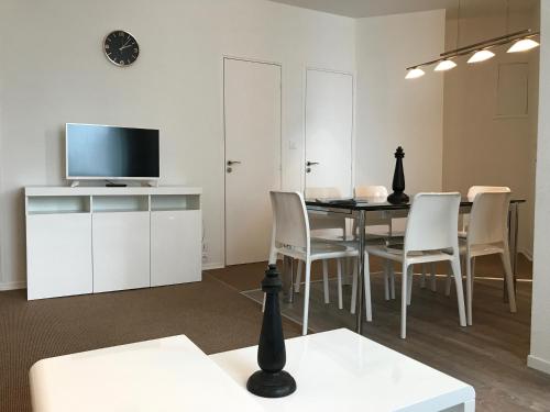 a living room with a table and chairs and a tv at Résidence Vendôme in Vichy