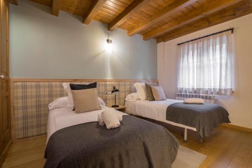 a room with two beds and a window at BARN THE RETREAT Apartamento premium en Esterri d'Àneu in Esterri d'Àneu