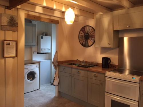 a kitchen with a sink and a washer and dryer at Lazydays Cottage in Moffat
