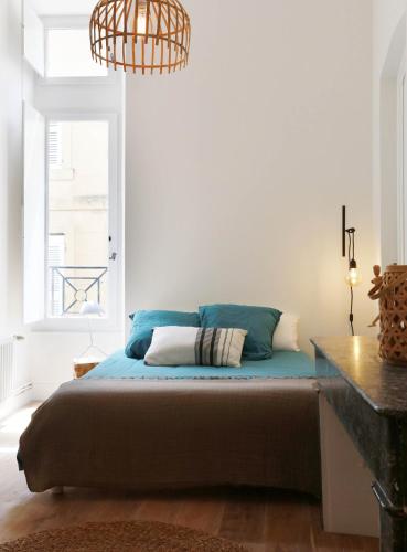 une chambre avec un lit et un lustre dans l'établissement Logement Hôtel Particulier centre ville, à Arles
