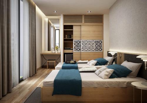 a bedroom with two beds with blue pillows at Villas at Oceanami Resort in Long Hai