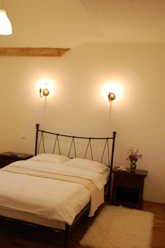 a bedroom with a bed with two lights on the wall at Cabana Moţilor in Mărişel