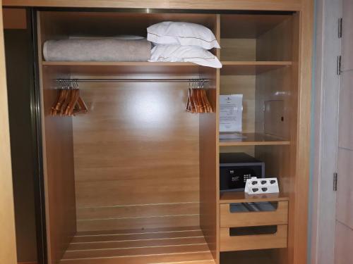 a closet with a wooden cabinet with towels on it at Hotel Presidente Luanda in Luanda