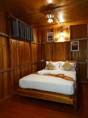 a bedroom with a bed in a wooden room at Lanta Para hut in Ko Lanta