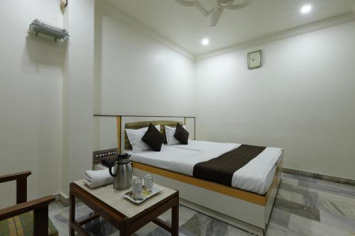 a hotel room with a bed and a table with a table sidx sidx at Hotel Good Night in Ahmedabad