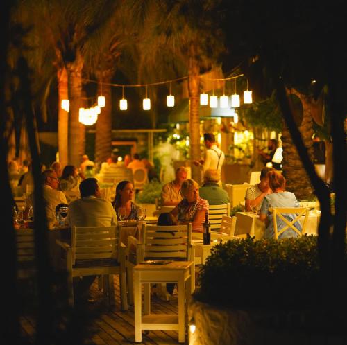 a group of people sitting at a restaurant at night at Yacht Classic Hotel - Boutique Class in Fethiye