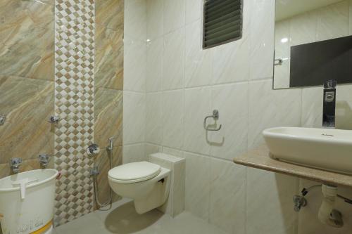 a bathroom with a toilet and a sink at Hotel Good Night in Ahmedabad