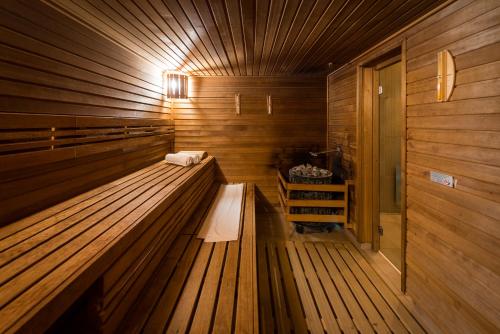 a sauna with two benches in a wooden room at Hotel Kaskáda in Kuřim