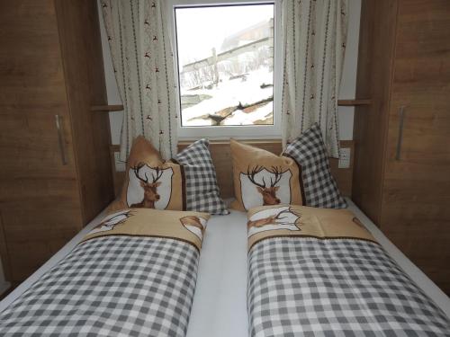 two beds in a small room with a window at Bergschlössl in Goldegg