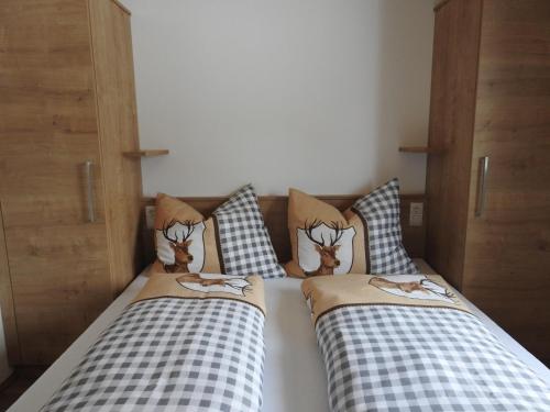 two beds with pillows with deer heads on them at Bergschlössl in Goldegg