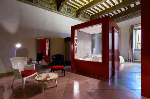 a room with a red door and a table and chairs at Palazzetto Rosso - Art Hotel in Siena