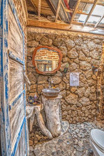 a stone bathroom with a sink and a toilet at Santhiku Hotel & SPA in Lovina