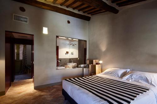una camera con un grande letto e uno specchio di Palazzetto Rosso - Art Hotel a Siena