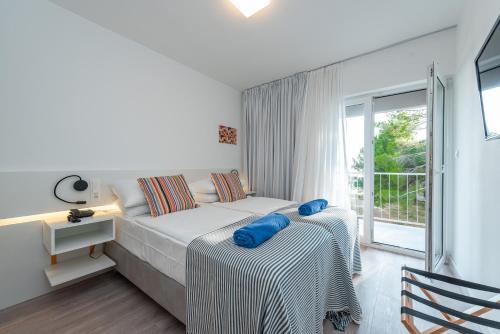 ein weißes Schlafzimmer mit einem Bett und einem Fenster in der Unterkunft Bluesun Holiday Village Alan in Starigrad-Paklenica