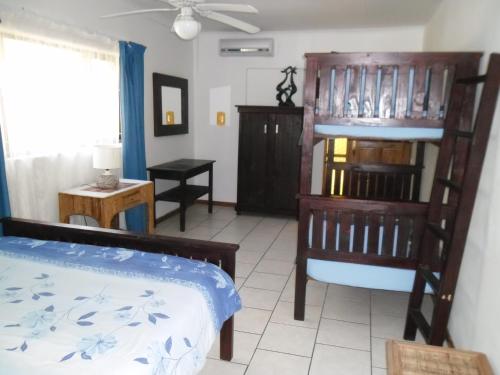a bedroom with a bed and a chair and a table at 57 Pelican Street in St Lucia