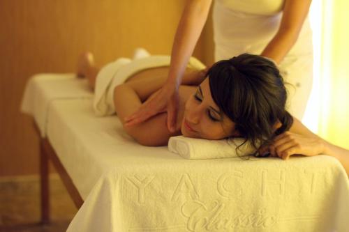 a woman laying on a bed while a woman is getting therapy at Yacht Classic Hotel - Boutique Class in Fethiye