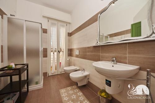 a bathroom with a sink and a toilet and a mirror at Villa Solelago Exclusive in Lonato