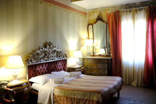a bedroom with a bed and two lamps and a mirror at Al Tuscany in Lucca
