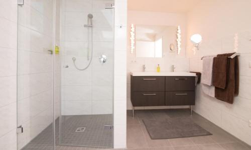 two images of a bathroom with a shower and a sink at FeWo "Staufner Domizil" Oberstaufen in Oberstaufen