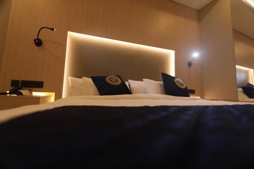a bedroom with a large bed with blue pillows at Noor jehan's Grand Noor in Palakkad