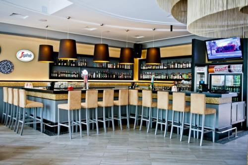 a bar with a bunch of stools in a restaurant at W Starej Kamienicy in Gniezno